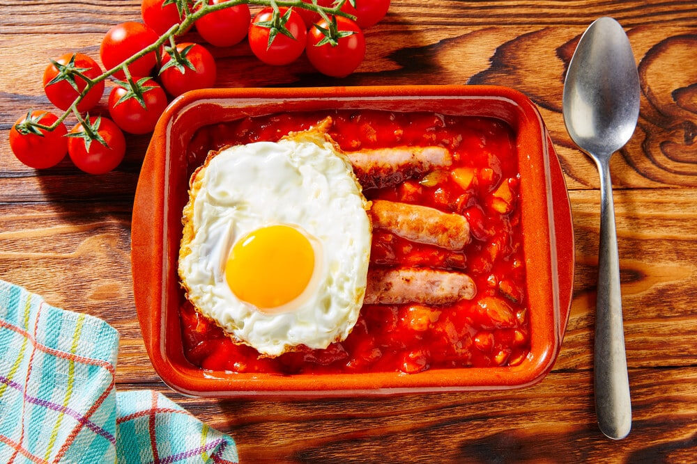 Овощное писто с яйцом и колбасками на фото