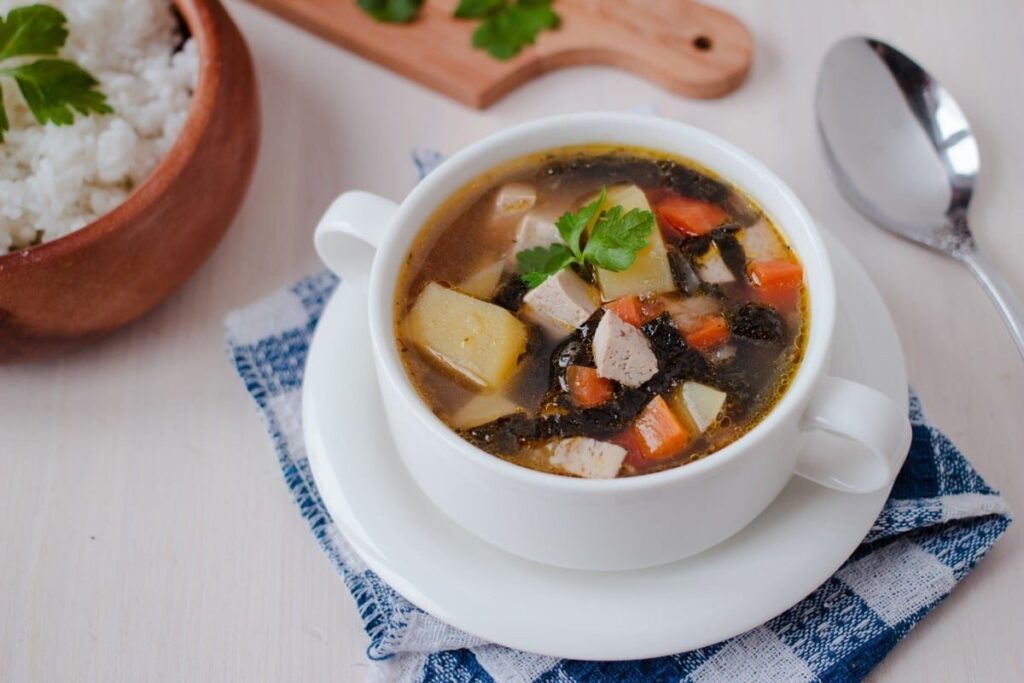 Картофельный суп с кубиками тофу и тёмными полосками нори в белой миске