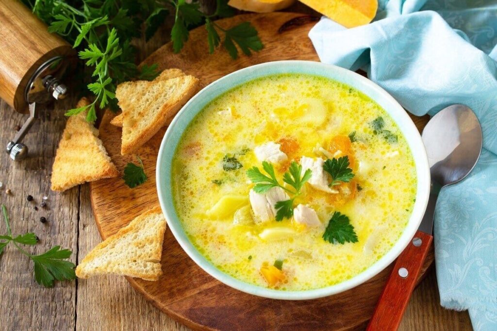 Суп с индейкой, тыквой, картофелем и зеленью в тарелке