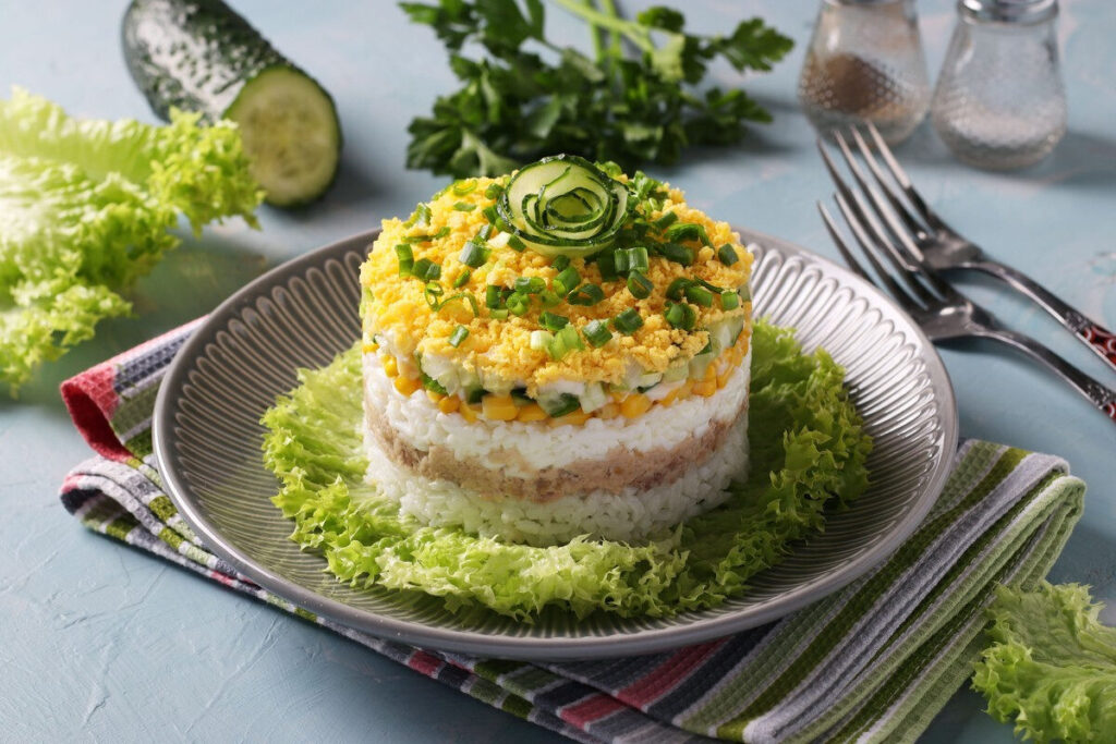 Слоёный салат с рисом, тунцом, яйцами и огурцами